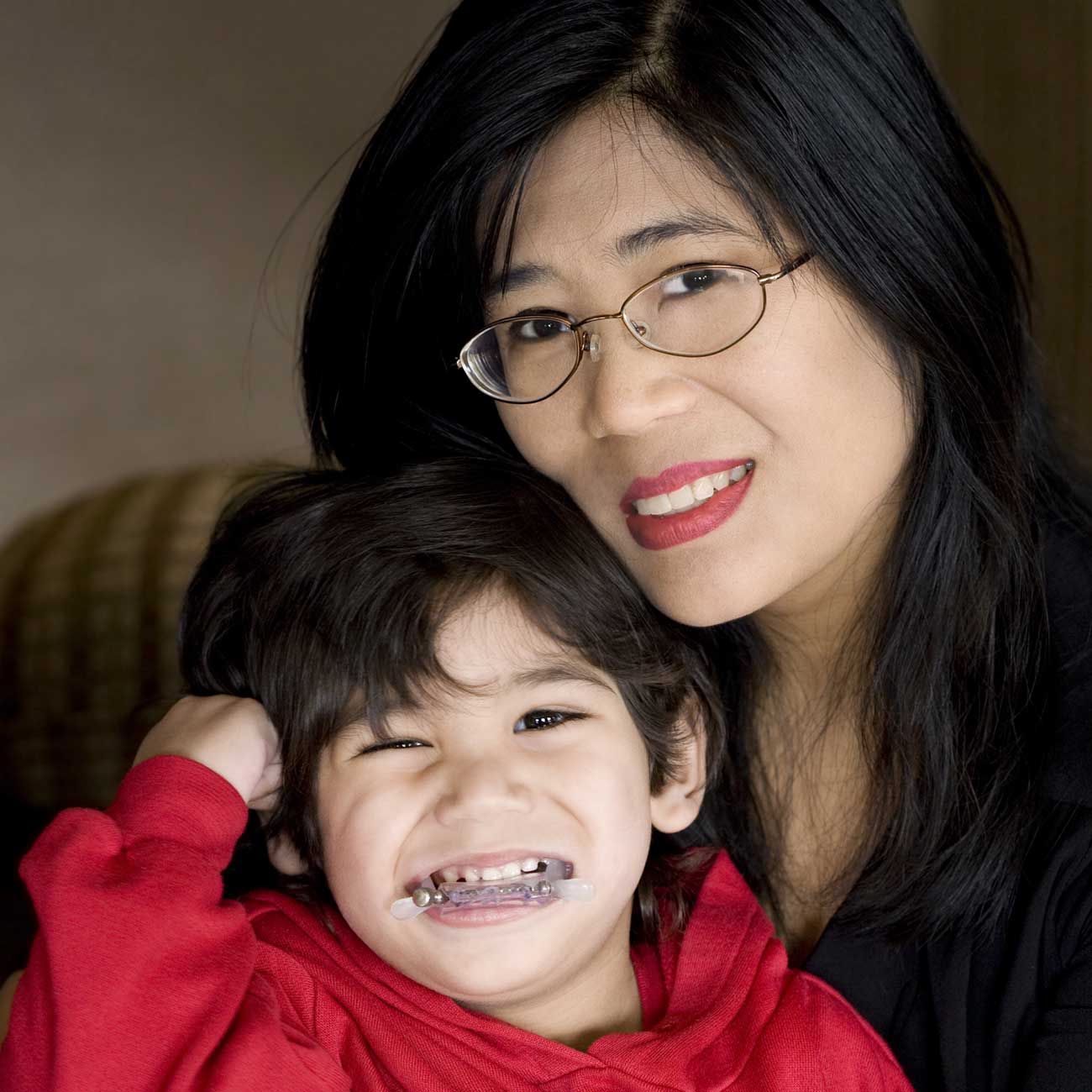 Mother smiling with her young child who has braces, representing families of children with developmental disabilities